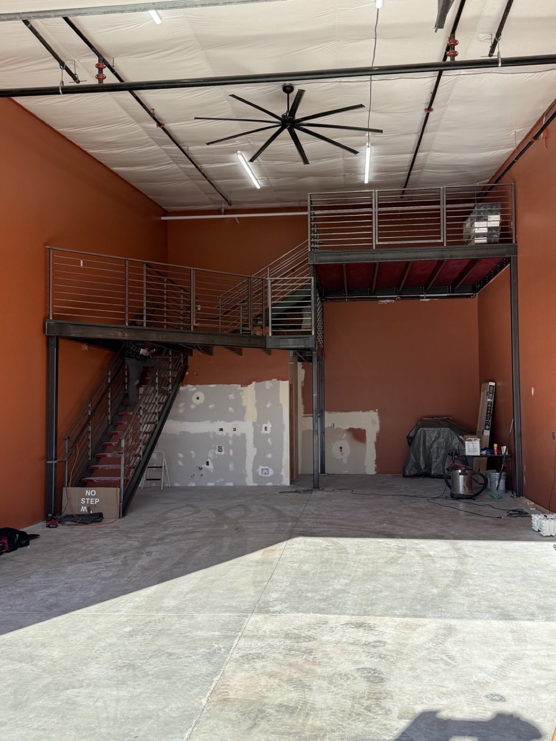 L-shaped mezzanine with a long stairway and wraparound railing